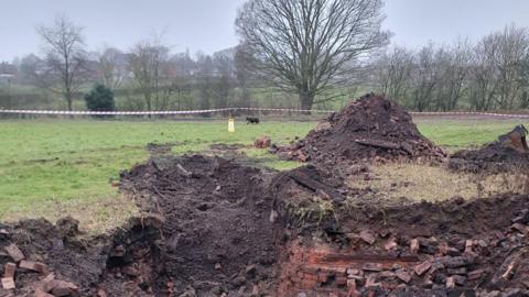 Exposed brickwork after an area of a field has been dug up 