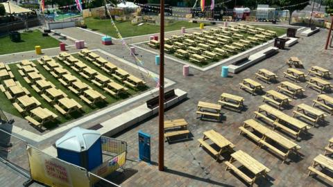 A number of picnic tables are pictured around a square in Leicester