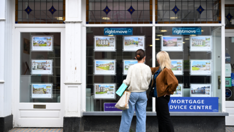 Two girls looking in an estate agents window