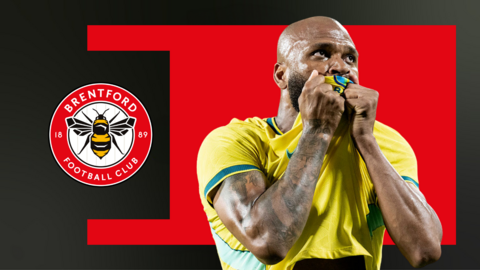 Igor Thiago kisses Brazil badge on shirt in front of red and black graphic background with Brentford badge