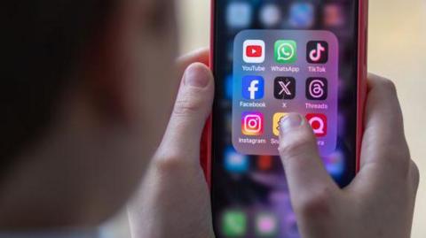 Generic image of a school child using a smartphone to look at social media