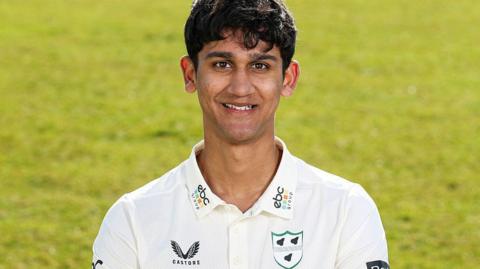 Rehaan Edavalath smiles in his white Worcestershire shirt