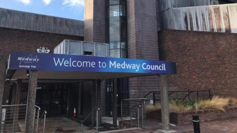 A building with a gantry over the front entrance. The gantry has a blue sign reading "Welcome to Medway Council" on it.