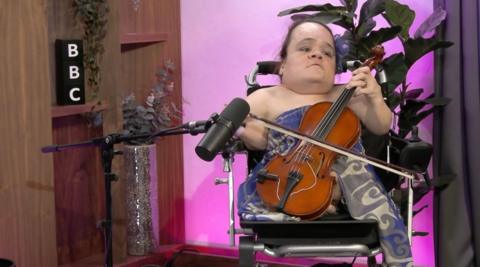 Gaelynn Lea plays a violin in the a BBC radio studio