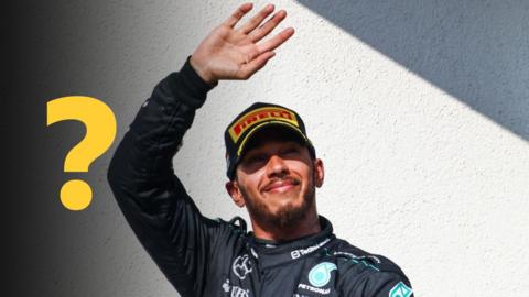 Lewis Hamilton waves while wearing a Mercedes race uniform. A question mark graphic is to the left of the image