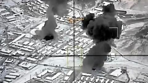 Black and white image of smoke rising from city.