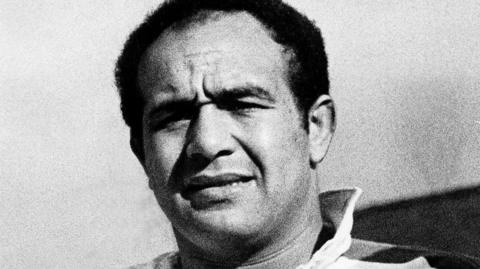 Billy Boston in a black and white photo looks forward