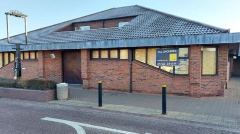 The outside of the former Ploughmans pub in Werrington which has boarded up windows and a for sale sign outside the front. 