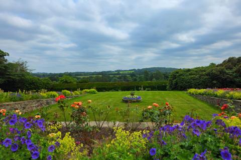 Colourful garden overlooking green countryside under cloudy skies in Cawthorne, Barnsley