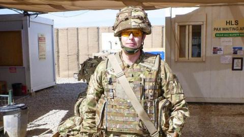 Gareth, wearing a protective helmet, gloves and goggles, also had to carry a 50kg body armour suit. He is pictured in Kabul, standing in a tented area 