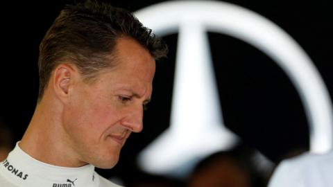 A 2012 photo of Schumacher in profile, looking down with the Mercedes logo behind him. 