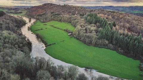 The River Wye winds its way though through lush green countryside. 