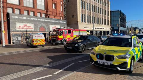 Emergency vehicles outside Blackpool Tower on Blackpool Promenade on a sunny day.