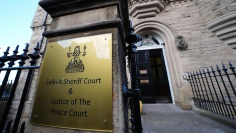 An external view of Selkirk Sheriff Court with its name on a brass plaque