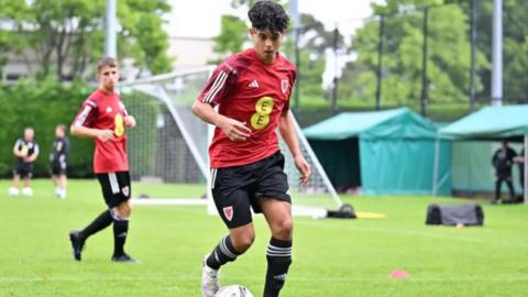 Enzo Romano, a teenage boy with black curly hair in a Wales kit