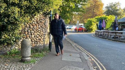 Stuart Worby arriving at Norwich Crown Court wearing a black puffa jacket and black trousers. 