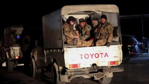 Syrian forces ride on military vehicles as they head to Latakia, after fighters linked to Syria's ousted leader Bashar al-Assad mounted a deadly attack on government forces on Thursday,