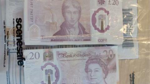 Counterfeit pound notes inside a plastic bag