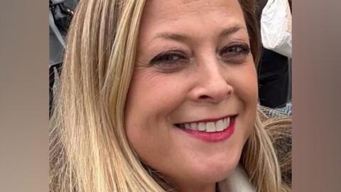 Close-up of Annabel Rook smiling at the camera. She had blonde hair and red lipstick.