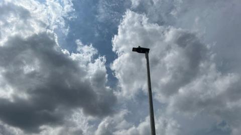 A street light in Devon with clouds and sky behind