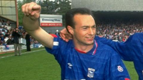 Simon Milton on the pitch at Portman Road with his right arm raised as Ipswich Town celebrate winning the old Second Division title in 1992