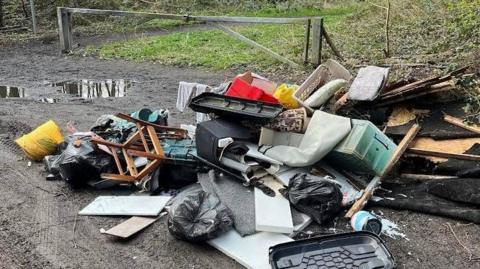 A heap of rubbish in a muddy layby