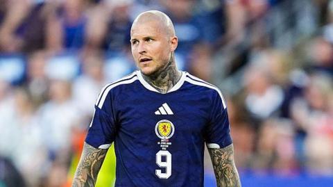 Lyndon Dykes wearing Scotland kit standing on the pitch during a World Cup game