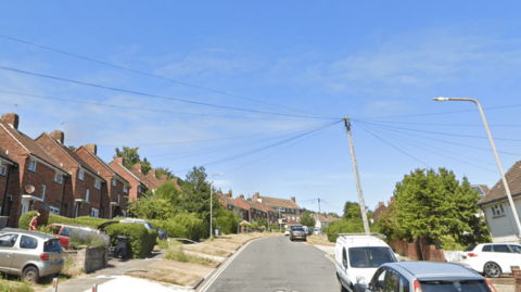 Surburban street with houses cars and trees