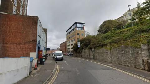 Google street view image of hinton road in Bournemouth. Their are apartment buildings on either side of the road.