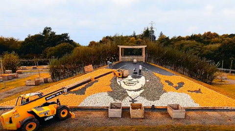 A pumpkin mural of Ozzy Osbourne being created