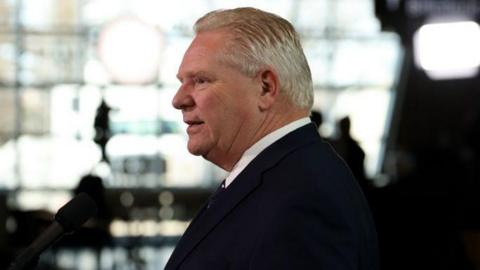 Doug Ford in suit turns his head to the side