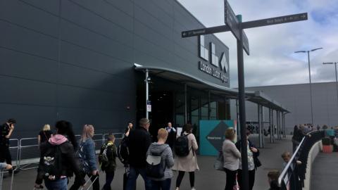 People walking with suitcases near the entrance of Luton Airport