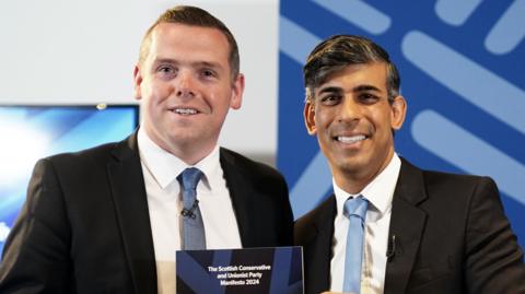 Douglas Ross and Rishi Sunak hold the Scottish Conservative election manifesto