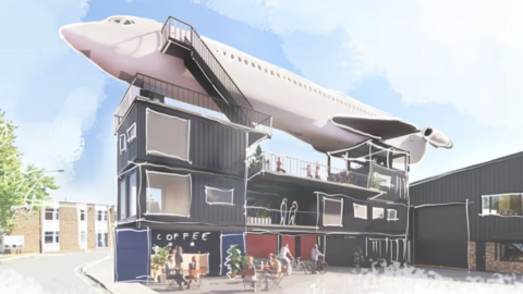 An artist's impression of a Boeing 727 mounted on top of several shipping containers. The lower level has a cafe saying 'coffee' and tables outside with people seated. Behind the structure is a residential street