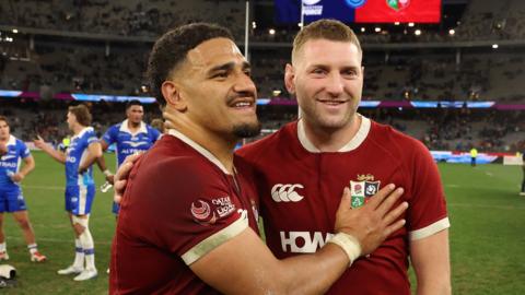 Sione Tuipulotu and Finn Russell celebrate on the pitch after the Lions beat Western Force