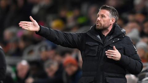 Rob Edwards gesturing towards his players on the pitch while manager of Luton