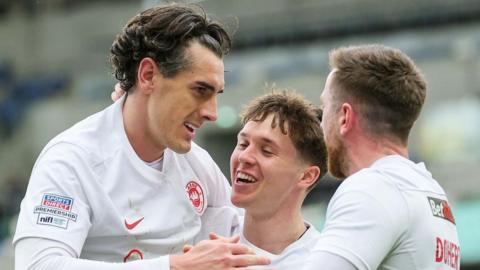 Matthew Ridley and Ronan Doherty congratulate Larne goalscorer Matty Lusty