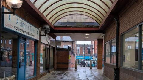 A canopy next to a shop with a Poundland in the background