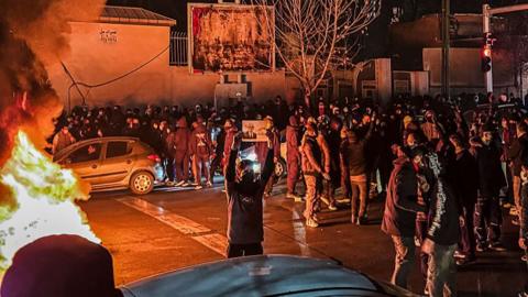A man holds up a picture while protesting in Tehran, Iran