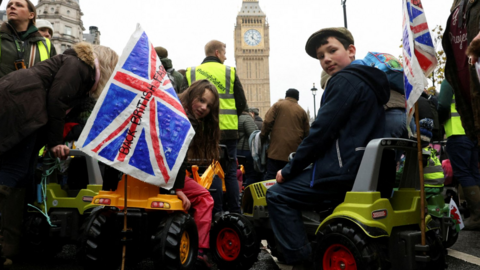 Eleanor, 6, and Jeffrey, 10, sit in toy tractors, as farmers protest against the Labour government's new agricultural policy, which includes a budget measure expected to increase inheritance tax liabilities for some farmers, in