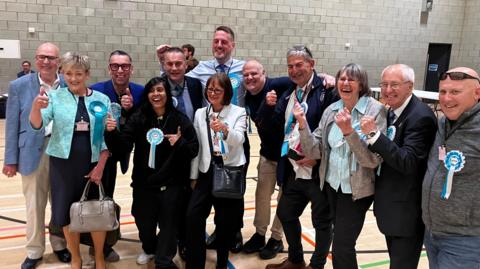 A group of Reform UK candidates celebrating.