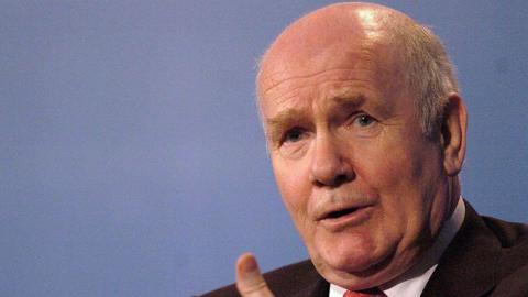 Close up shot of John Reid talking as he gestures with his hands.