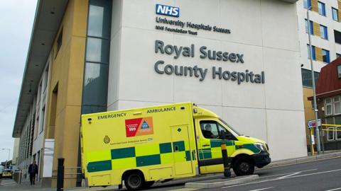 An ambulance driving past one of the entrances to the Royal Sussex County Hospital in Brighton, East Sussex.