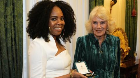 Queen Camilla presents Selina Brown with her medal during a reception for authors, members of the literary community and representatives from the Queen's Reading Room, to celebrate the first recipients of the Queen's Reading Room Medal, at Clarence House,