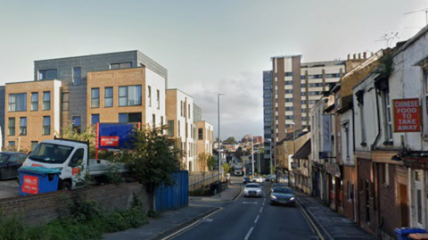 A street view of Upper Stone Street in Maidstone shows cars driving along a road lined with residential and commercial buildings on either side.