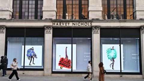 People walking past a luxury department store in Knightsbidge, London 