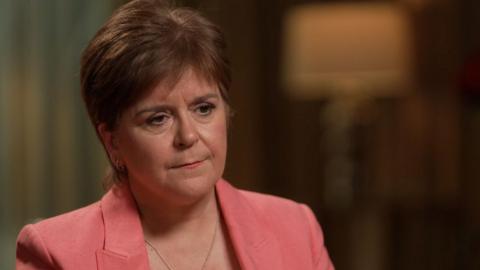 Head and shoulder shot of Nicola Sturgeon. She is wearing a pink blazer and looking to the side.