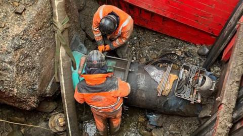 Engineers seen fixing a water pipe