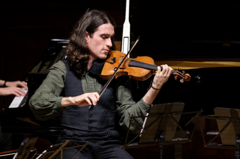 David Lopez Ibanez plays the violin on a stage 