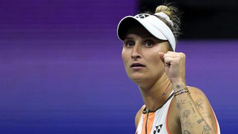 A woman, Marketa Vondrousova, raises a clenched left fist